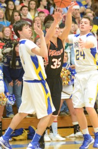 Jordan Stookey of Warsaw looks to pass the ball through the defense of Triton's Joey Corder (at left) and Tanner Shepherd in Bourbon Tuesday night.