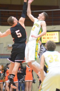 John Swanson (at left) of Warsaw goes up for the opening tip-off with Nate Richie of Northridge Saturday night at North Side Gym.