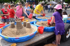 Children were able to take part in a sand castle competition in downtown Warsaw by utilize kiddie pools filled with moist sand.  (photo by Alyssa Richardson)