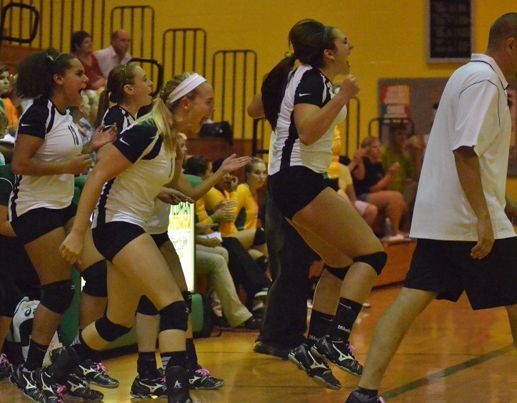 The Lady Warrior bench reacts to the winning point Tuesday night in Akron.