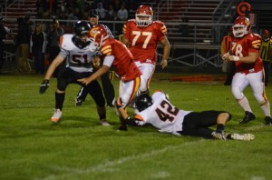 Kyle Heckaman (No. 42) slows Trevor Trowbridge of Memorial as Ben Plummer (No. 51) closes in for the Tigers.