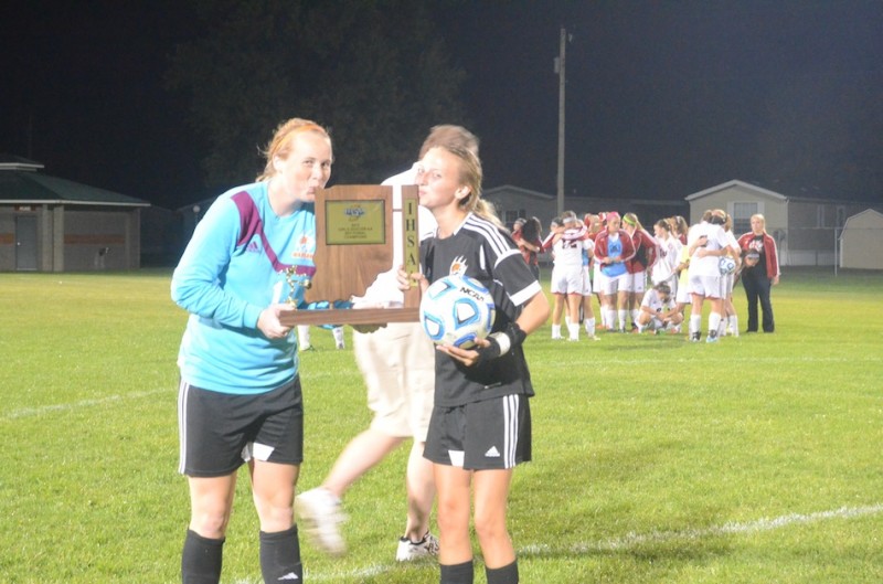 Warsaw's Abby Schue (left) and Danielle Hutcherson plant a kiss on the sectional championship trophy Saturday night in Plymouth. The Tigers play No. 14 Northridge Wednesday in the Goshen Regional.