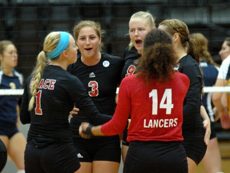 Members of the Grace College volleyball team celebrate during a 3-1 win at Marian in the conference tournament Tuesday night (Photo provided by Grace College Sports Information Department)