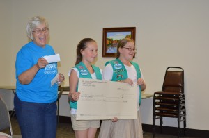 Girl Scout Leader Barb Grumme, left Girl Scout Sophia Grumme and Girl Scout Aly Kirkpatrick, all of Troop No. 00148 presented the Syracuse Park Board with a check for $1,500 to purchase a swing for handicapped individuals to use. The girls requested approval from the park board to proceed with fundraising for the project, which the park board gave. Not pictured are Tina Walton, assistant leader, and Andrea Chaney, community liaison for the troop.