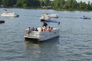 Boaters gather around the SS Lilly Pad II for Sunday morning worship services each week on Lake Wawasee