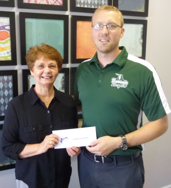 Sue Creighton, Beaman Home Capital Campaign Chair, accepts a $950 check from Dr. Erick Leffler, president of the Syracuse-Wawasee Rotary Club. (Photo provided)