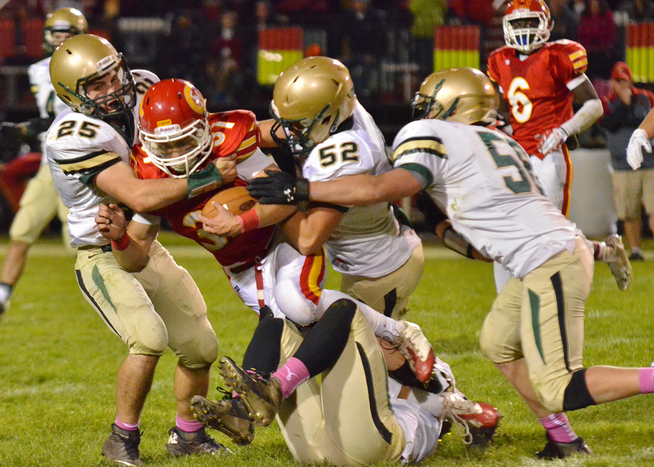 Wawasee defenders Nathan Katzer (25), Maclain Herr (52) and Stephen Possell (58) converge on Elkhart Memorial's Andrew Goodman during Wawasee's 20-7 win at Memorial Friday night. (Photo provided)