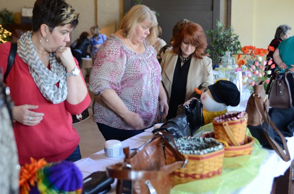 Lisa Creager, Kate Houck and Geanie Edgington view the silent auction handbags