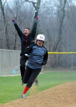 Grace's Ashley Kleinbub sprints home for the game-winning run against Taylor while assistant coach Jay Johnson celebrates.