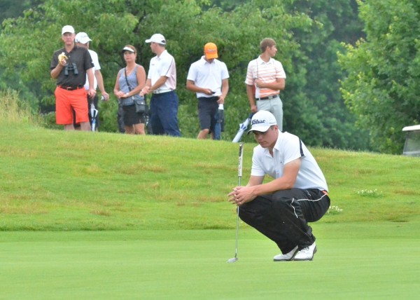 Jonny Hollar studies the green while the Warsaw fan section waits patiently in the backdrop. 