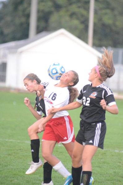 A trio of players make a play for the ball during the Warsaw at Goshen match Tuesday night. The Tigers topped the No. 19 Redskins 1-0 in a huge NLC match.