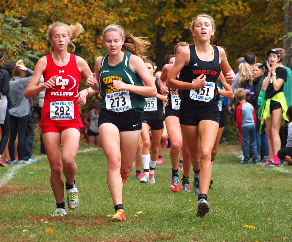 Mia Beckham of Warsaw runs with Crown Point's Anna DeMars and Benton Central's Isabel Weise.