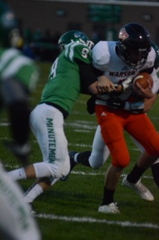 Warsaw quarterback Michael Jensen is wrapped up by Concord's Seth Shroyer.