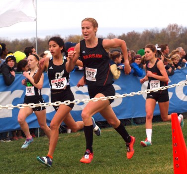 Warsaw's Allison Miller (628) works her way past Ensley Hammond of Columbus North (395) at the end of Saturday's IHSAA girls state cross country finals in Terre Haute. Trailing is Warsaw's Emma Hayward (625). (Photo by Tim Creason)