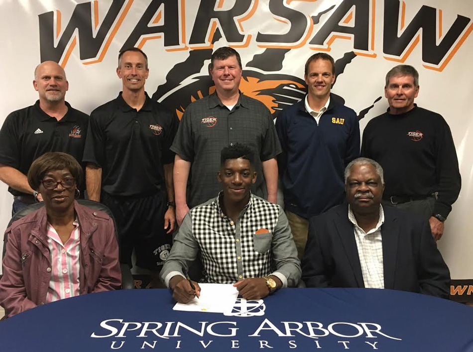 Warsaw Community High School senior Paul Marandet has signed a letter of intent to continue his basketball career at Spring Arbor University. Seated with Paul are parents PICTURED (L-R, Front): Honorine Marandet, Paul Marandet, Noe Marandet; (L-R, Back): Dave Anson (WCHS Athletic Director, David Wayne (WCHS Associate Head Coach), Doug Ogle (WCHS Head Coach), Ryan Cottingham (Spring Arbor Coach), Hal Gunter (WCHS Assistant Coach).