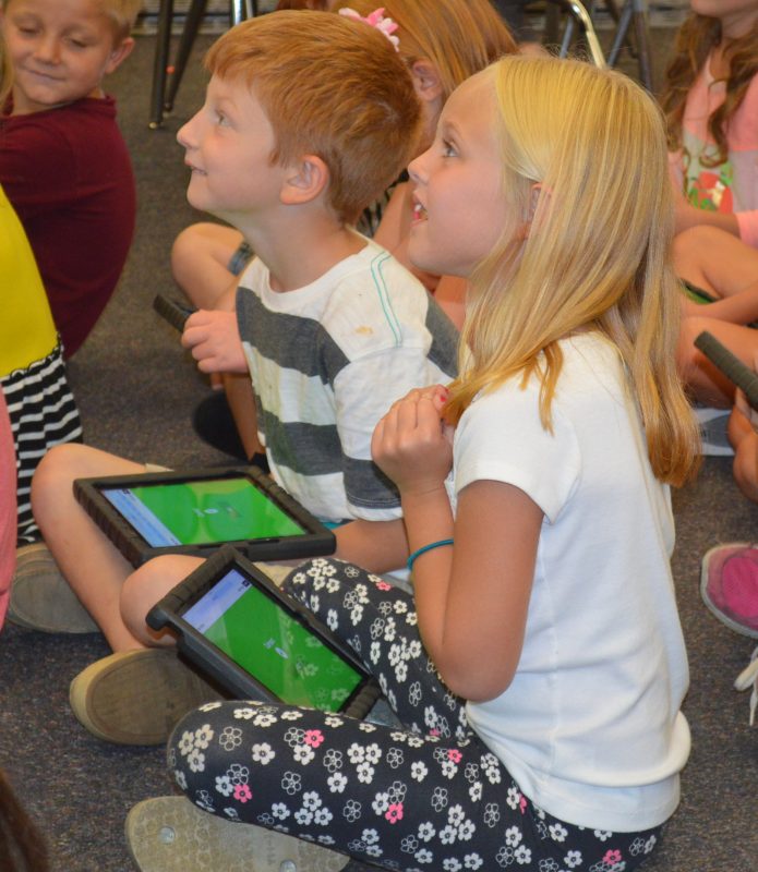 Jaxon Fawley, left, and Sophia Maule are anticipating seeing the results of a math exercise they had been doing on their iPads in Julie Hays’ second-grade classroom at Syracuse Elementary.