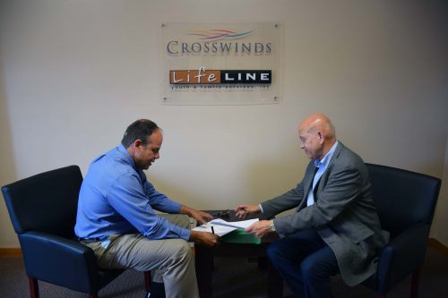 Mark Terrell, CEO of Lifeline and William Katip, President of Grace College sign the paperwork for the partnership.