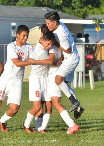 Jesus Jimenez (middle) is mauled by teammates after scoring the first goal of Saturday's championship game. (Photos by Nick Goralczyk)